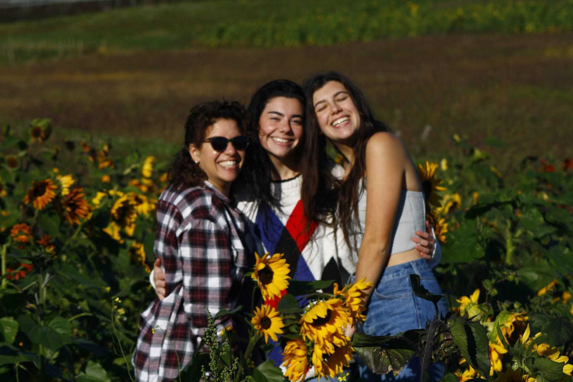 Karin with her daughters in a sunflower field at golden hour